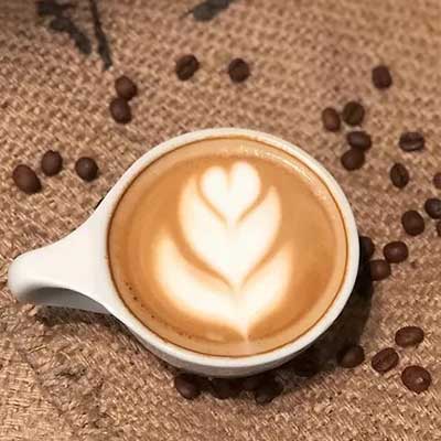 cortado drink in cup with cream decor